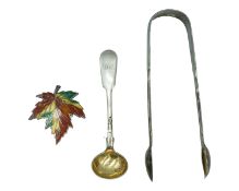 A Victoria silver pair of sugar tongs, a Victoria silver mustard spoon, and a silver and enamel mapl