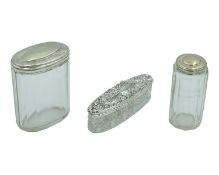 A trio of Victorian and later silver-lidded cosmetic pots.