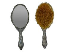 A silver-backed hand mirror and hairbrush by Walker & Hall.