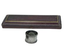 A silver napkin ring by Thomas Hayes.