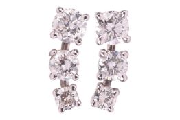 A pair of diamond-set stud earrings, each consisting of three graduated round brilliant-cut diamonds