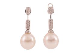 A pair of South Sea cultured pearl and diamond drop earrings, each comprising a large egg-shaped whi