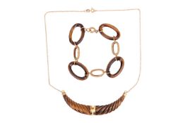 A tiger's eye necklace and a bracelet; the necklace comprising a hinged tiger's eye pendant carved a