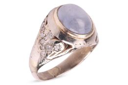 A star sapphire and diamond-set ring, centrally set with an oval sapphire cabochon, displaying aster