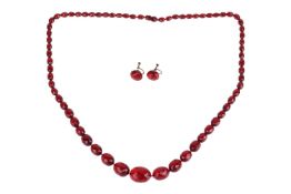 A cherry bakelite necklace and earrings set; the necklace comprising graduated faceted bakelite bead