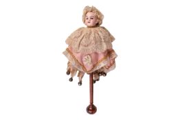 A German bisque head Marotte doll, with working musical sound, on original wooden pole with bells at