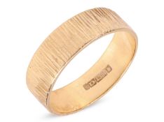 A textured band ring, the flat band with hand forged bark effect, yellow metal struck with South Afr