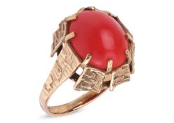 A coral cabochon dress ring, set with an oval corallium rubrum cabochon of 12.3mm x 10.1mm x 4.4mm, 
