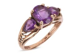 An amethyst trilogy ring, centred with an oval-cut amethyst flanked by further two pear-cut amethyst