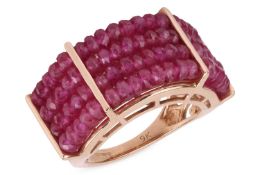 A ruby bead ring, composed of four rows of faceted ruby beads, to pierced tapered shoulders, mounted