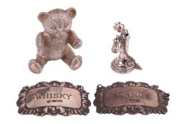 A silver teddy bear figurine, a silver candlestick telephone miniature, and a pair of silver decante