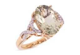 A tourmaline and diamond dress ring in 18ct gold, comprising an oval-cut pale green tourmaline of 13