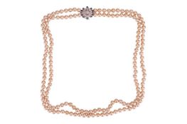 An imitation pearl double-strand necklace, leading to a diamond and sapphire-set white metal clasp, 