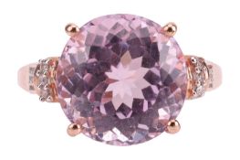 A kunzite dress ring in 9ct gold, centred with a circular-cut kunzite of 11.8 mm, between diamond-se