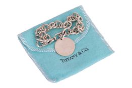 Tiffany & Co. - a silver bracelet with round plaque, signed and struck with British assay marks,