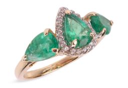 An emerald dress ring, composed of three pear-shaped emeralds, the central emerald within a surround