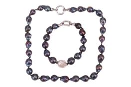 A baroque pearl necklace and matching bracelet, the treated black baroque pearls leading to an open 