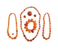 A collection of amber jewellery, comprising of three single-strand rows of 9.4mm - 14.4mm oval varie