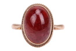 A spinel cabochon ring in 9ct gold, collet-set with an oval red spinel hollow cabochon of 14.0 x 9.0