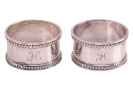 A pair of cased silver napkin rings, by T H Hazlewood & Co., Birmingham 1908, with gadrooned bor