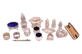 A small group of silver items comprising a tea caddy and spoon, a sugar shifter, a cruet set with pe