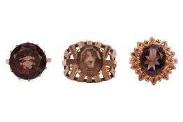 Three smoky quartz rings, featuring a claw-set smoky quartz solitaire ring, in 9ct yellow gold, size