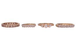 Four gem-set rings; The first a colourless sapphire eternity ring, in yellow metal stamped '9ct' rin