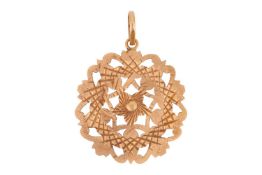 A pierced medallion pendant, of floral design, with sunburst engine-turned finish, on a suspension l