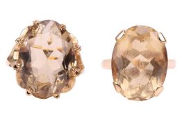 Two 9ct gold citrine dress rings; the first comprising an oval-cut citrine in carved claw mount, siz