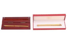 Two Must De Cartier pens, both of textured design with trinity accents to the covers, one boxed.