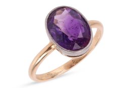 An amethyst ring, in a bezel setting, with millegrain edge detailing, the ring unmarked, the head of