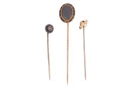 Three stick pins; The first a gem-set stick pin (gem loose), the head of circular form with pointed 
