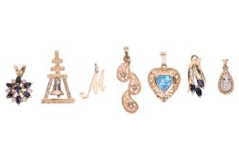 A small group of seven pendant charms, all marked '14K' or surface testing as 14ct, comprising a sap