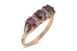 A ruby and diamond-set ring, featuring three oval-shaped rubies of deep purplish-red colour, each in