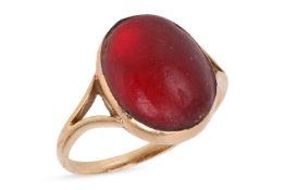 A paste cabochon dress ring, collet-set with an oval red paste cabochon, in a closed-back mount betw