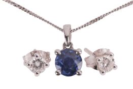 A sapphire pendant and diamond stud earrings, the sapphire pendant featuring a round blue sapphire (