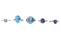 Five blue topaz rings; two with diamond-set shoulders, one fancy-cut with a diamond within, and two 