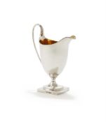 A GEORGE III SILVER HELMET CREAM JUG
