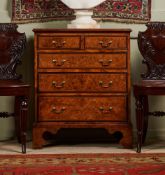 A GEORGE III BURR ELM AND CROSSBANDED CHEST OF DRAWERS, CIRCA 1790