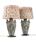 A PAIR OF BRONZED AND PATINATED TWIN-HANDLED TABLE LAMPS, IN THE MANNER OF JAMES MONT