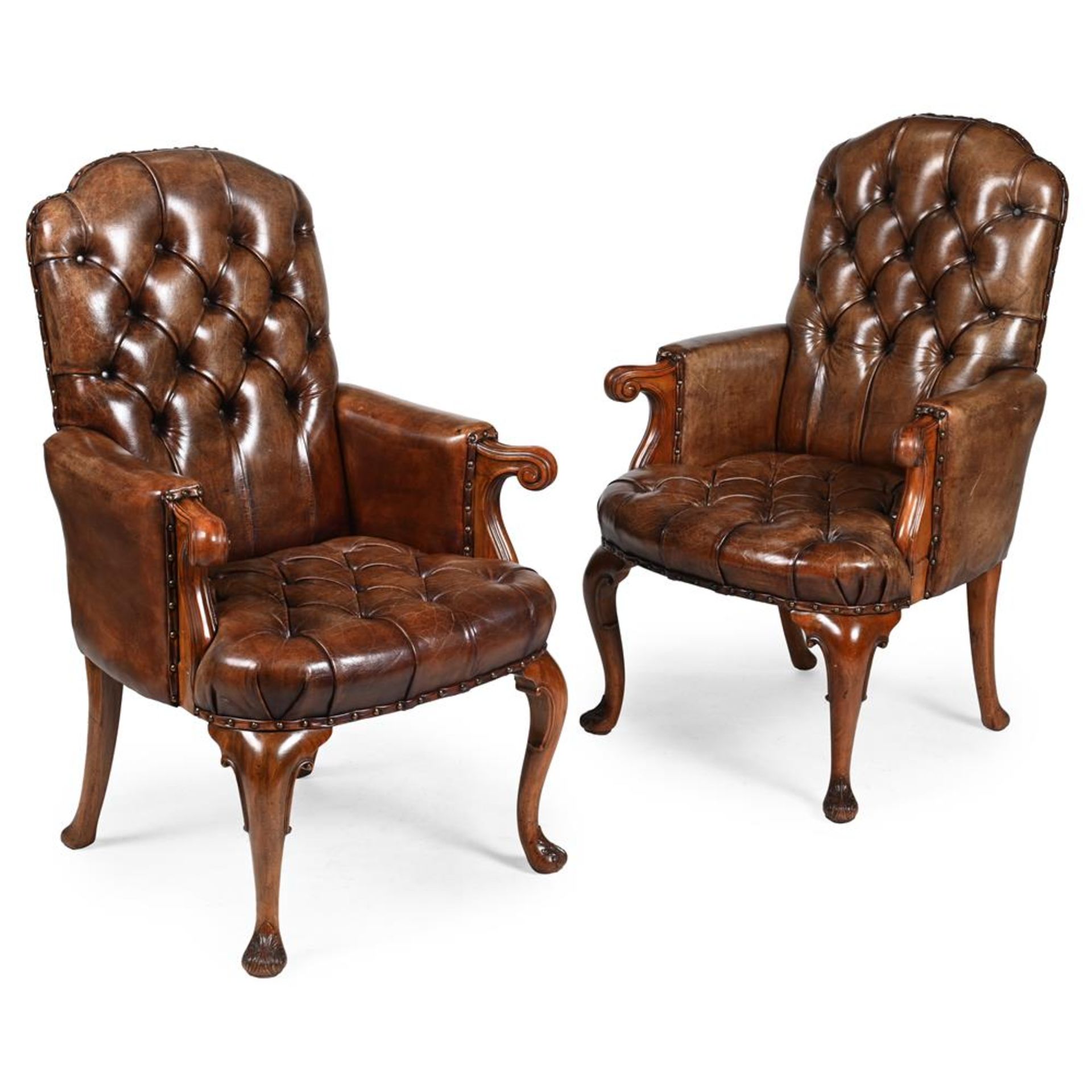 A PAIR OF WALNUT AND BUTTONED LEATHER UPHOLSTERED LIBRARY ARMCHAIRS, IN GEORGE I STYLE