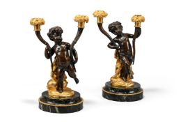 A PAIR OF FRENCH GILT AND PATINATED BRONZE CHERUB BASE CANDLESTICKS, IN THE MANNER OF CLODION