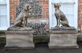 A LARGE PAIR OF COMPOSITION STONE SEATED DOGS ON PEDESTALS, CONTEMPORARY