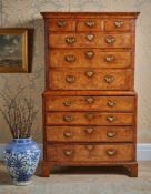 A GEORGE II BURR WALNUT AND FEATHERBANDED SECRETAIRE CHEST ON CHEST, CIRCA 1730