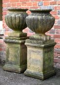 A PAIR OF COMPOSITION STONE URNS ON STANDS, LATE 20TH CENTURY