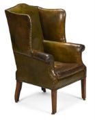 A GEORGE III MAHOGANY, BRASS STUDDED AND GREEN LEATHER UPHOLSTERED WING ARMCHAIR, CIRCA 1780