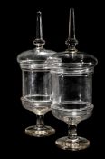 A PAIR OF CLEAR GLASS PEDESTAL CHEMIST JARS AND COVERS