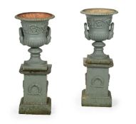 A SMALL PAIR OF CAST IRON URNS ON STANDS IN THE HANDYSIDE PATTERN, 20TH CENTURY