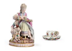 A MEISSEN PORCELAIN FIGURAL GROUP 'THE BROKEN EGGS', 19TH CENTURY, TOGETHER WITH A CUP & SAUCER