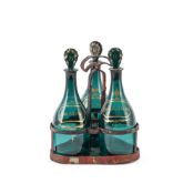 A SET OF THREE GREEN-GLASS AND GILT MALLET-SHAPED DECANTERS AND STOPPERS, THE GLASS CIRCA 1790